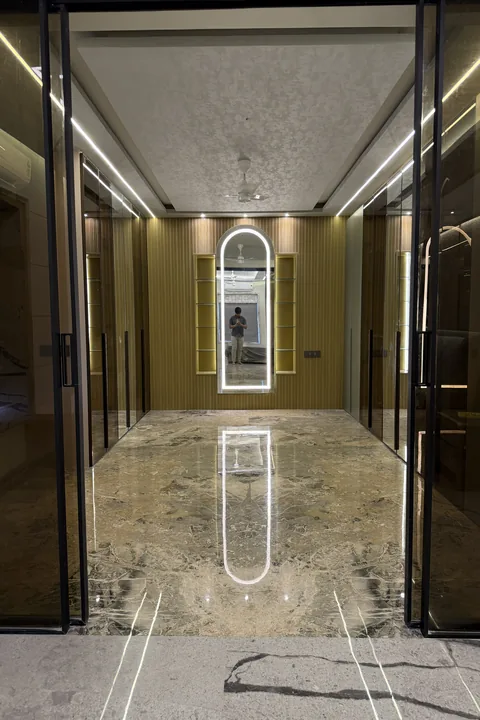 Marble corridor with brass trims and a mirrored end wall, built by Kalky Interior