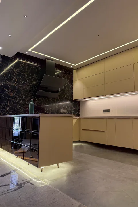 Modular kitchen in cream with a black marble splashback, built in the Kalky Interior factory
