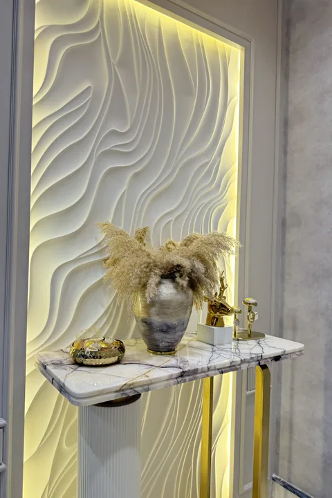 Foyer console beneath a backlit three-dimensional textured wall panel, by Kalky Interior