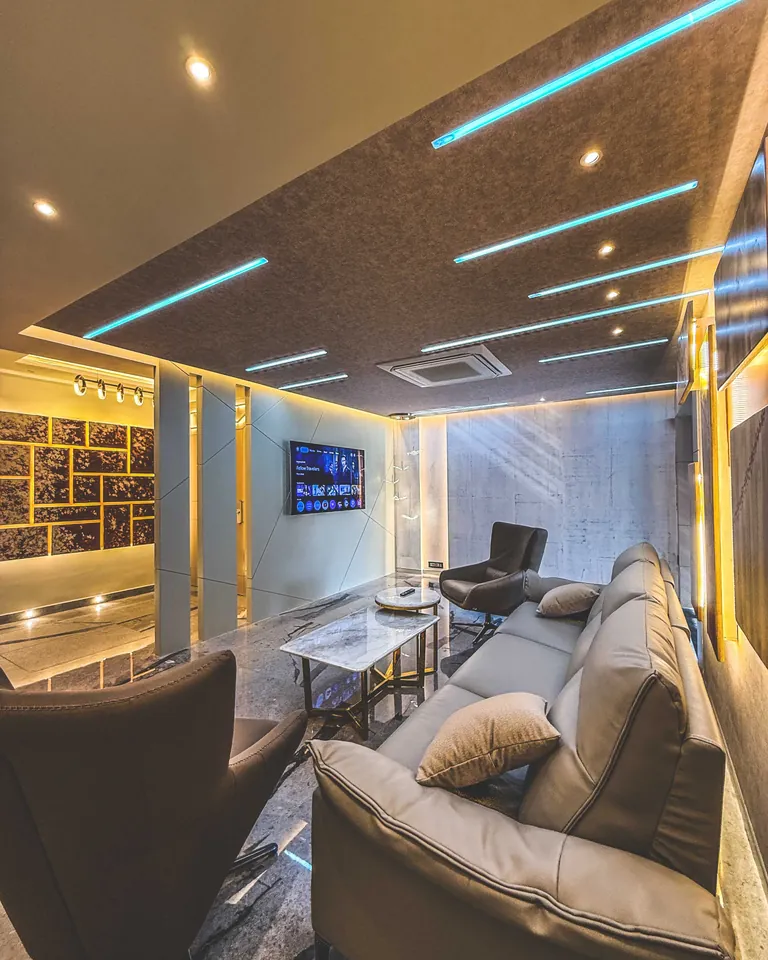 Living room with a backlit false ceiling, wall panelling and a corner sofa, built by Kalky Interior in Bhubaneswar