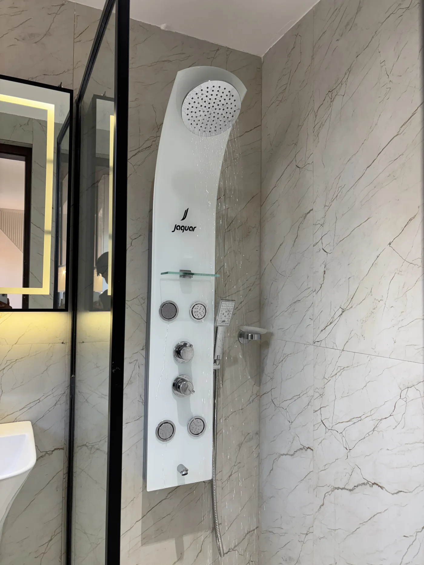 Bathroom vanity with a backlit mirror and stone counter