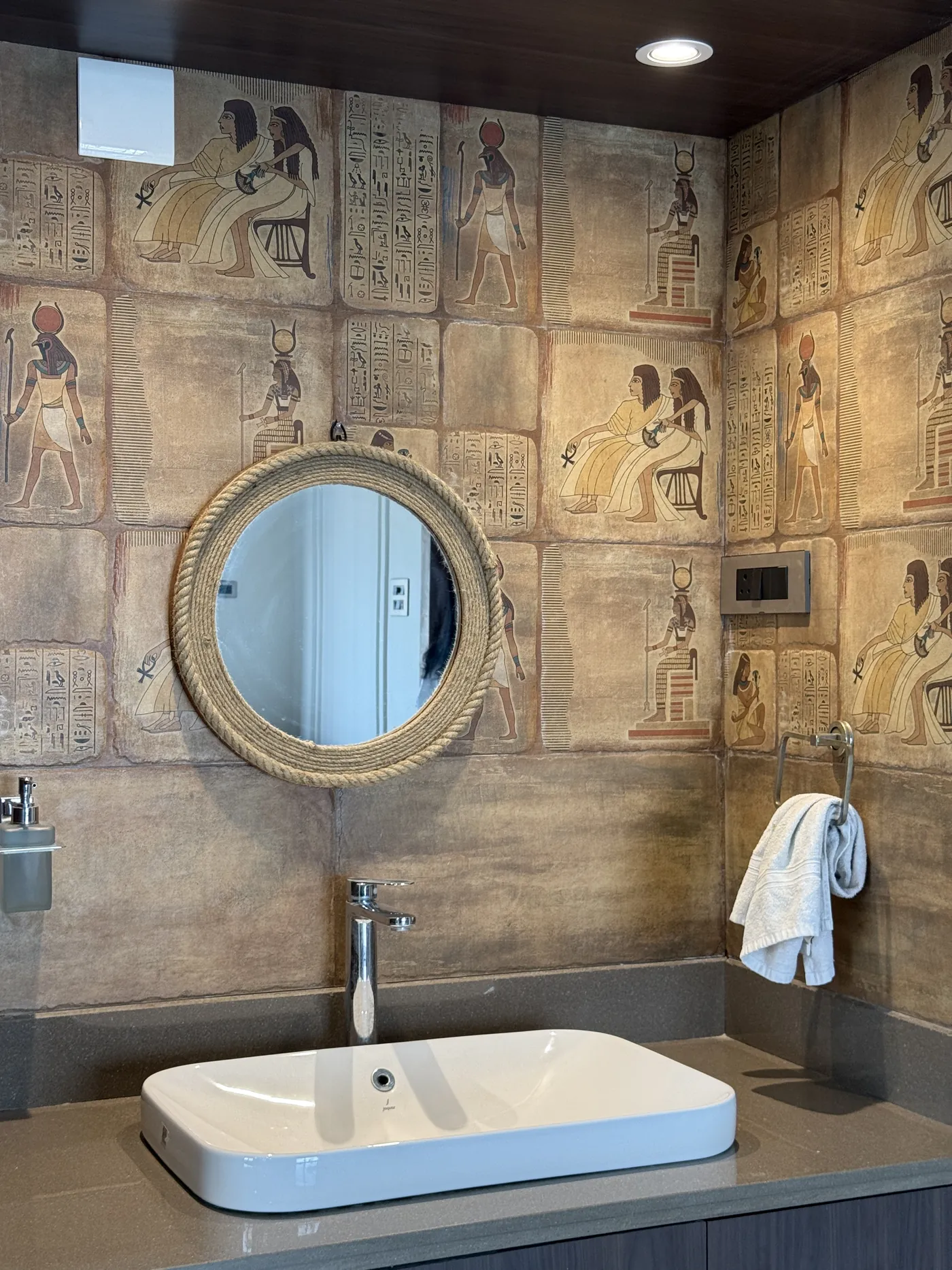 Bathroom with a motif-printed tiled wall and a vessel basin