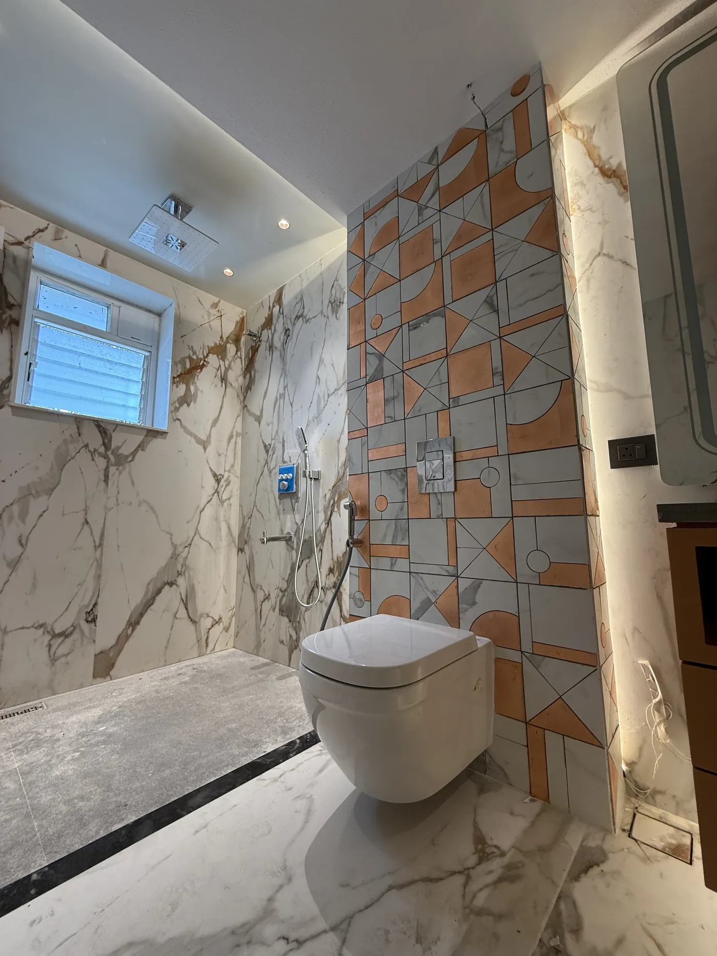 Bathroom with a wall-hung WC and a patterned stone feature wall