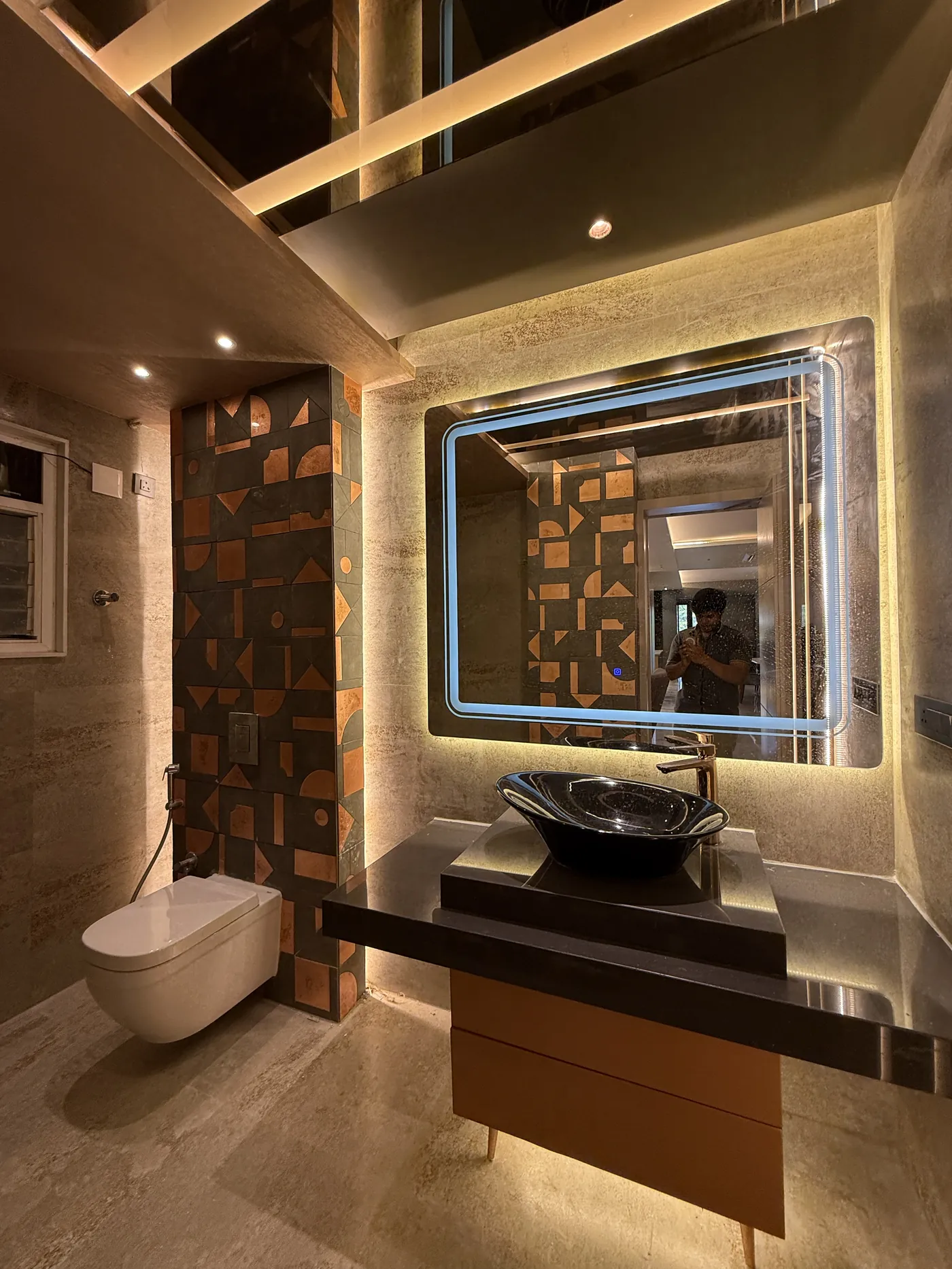 Bathroom with a backlit mirror, timber wall panel and a stone counter