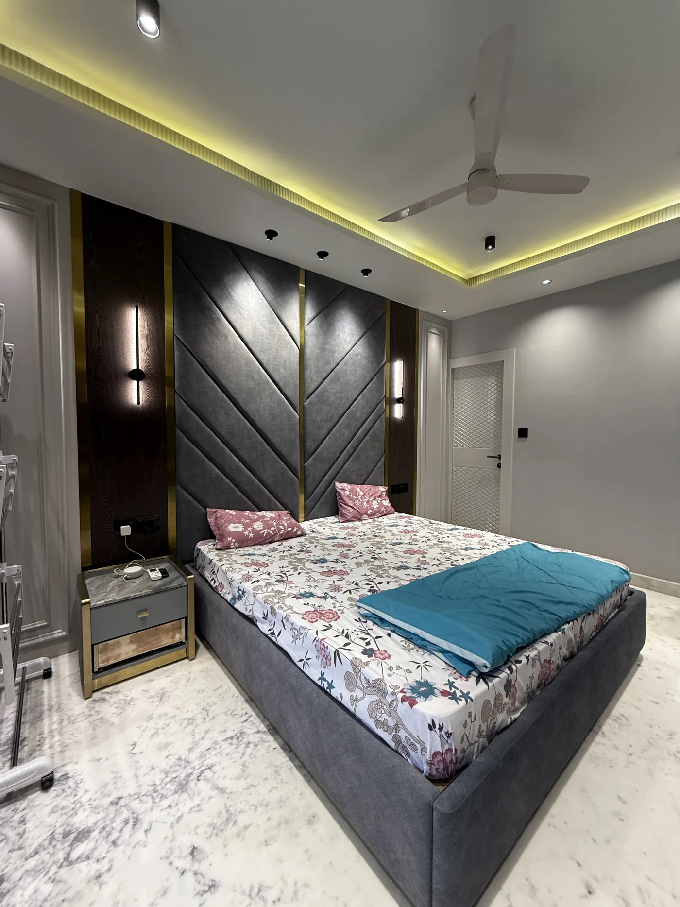 Bedroom with an upholstered panelled headboard and cove lighting