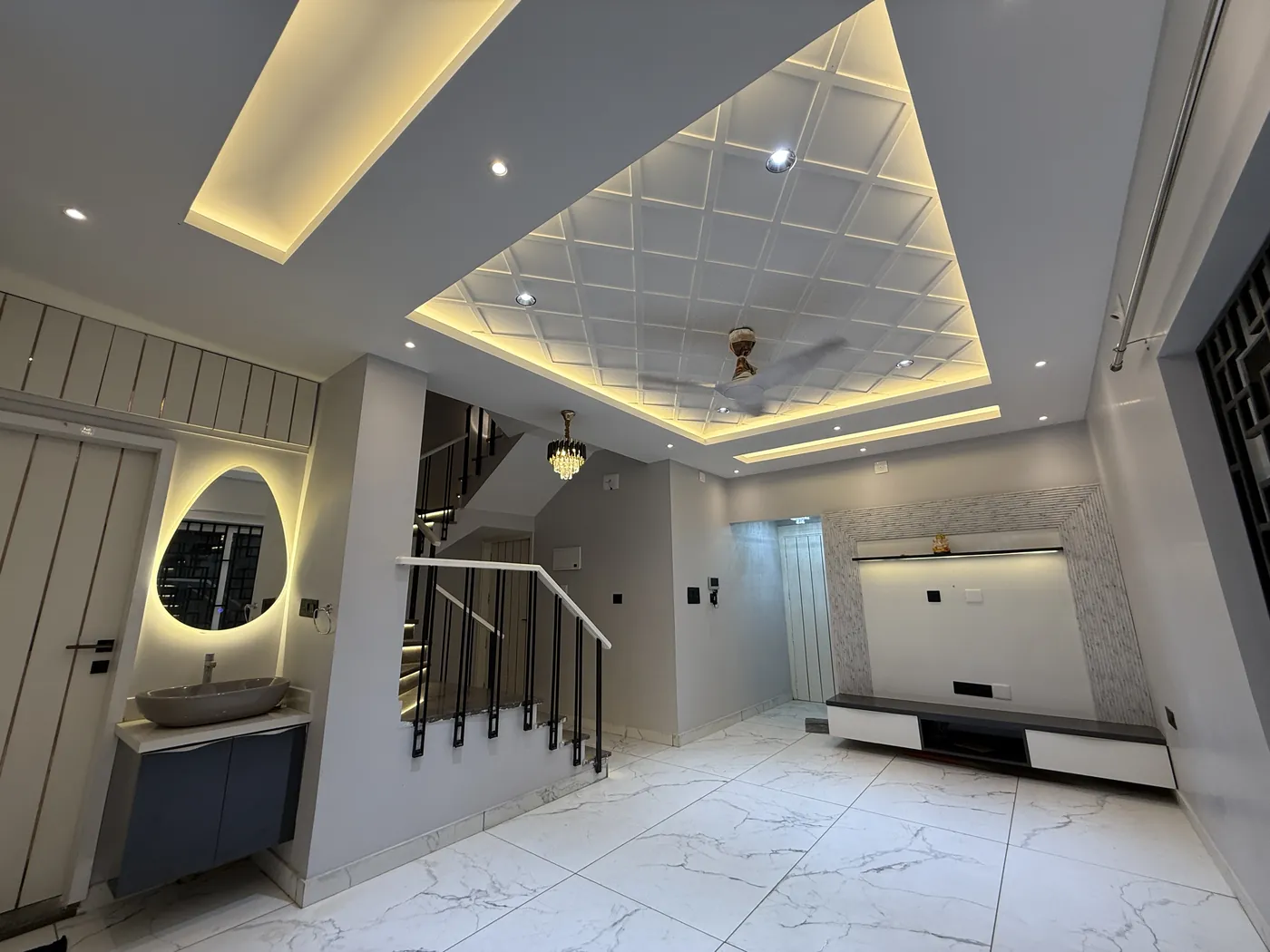 Coffered false ceiling with cove lighting over a hallway and staircase