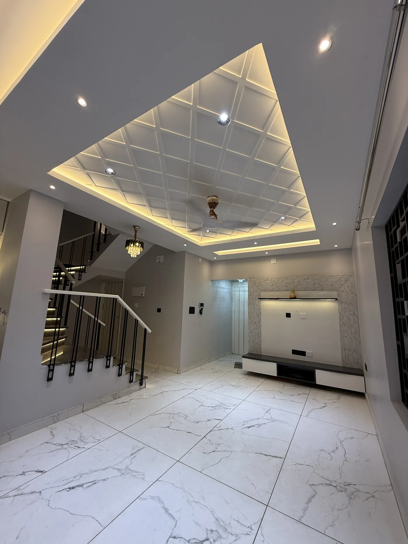 Staircase hall with a coffered ceiling and a backlit mirror