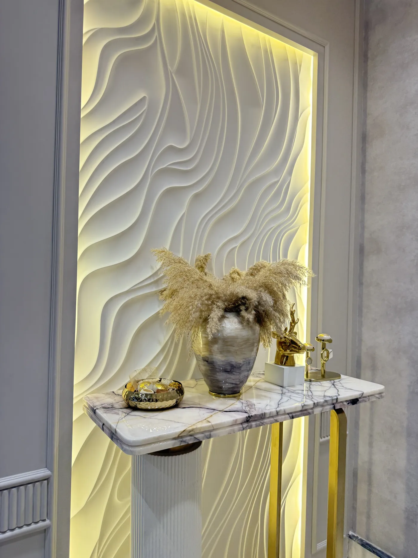 Foyer console beneath a backlit three-dimensional textured wall panel