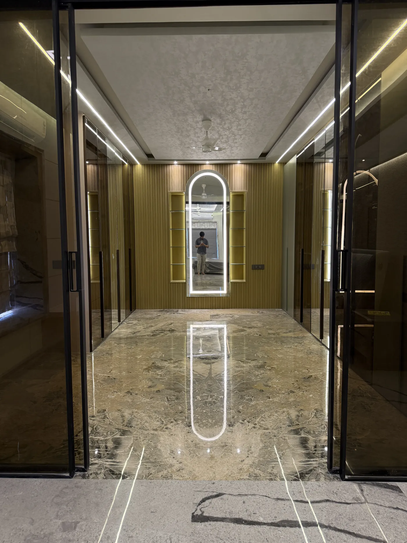 Marble corridor with brass trims and a mirrored end wall