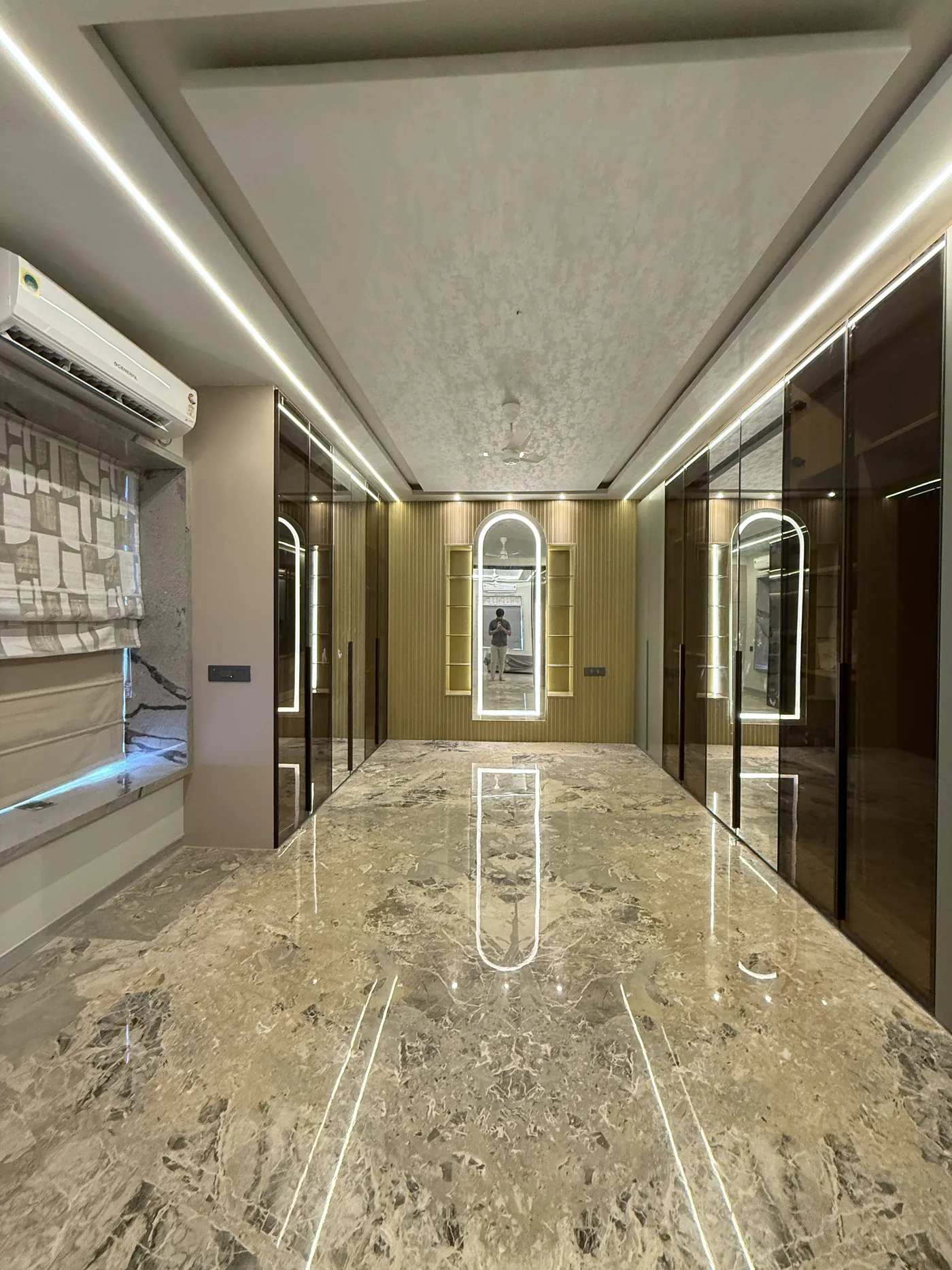 Marble-floored corridor with arched doorways and cove lighting