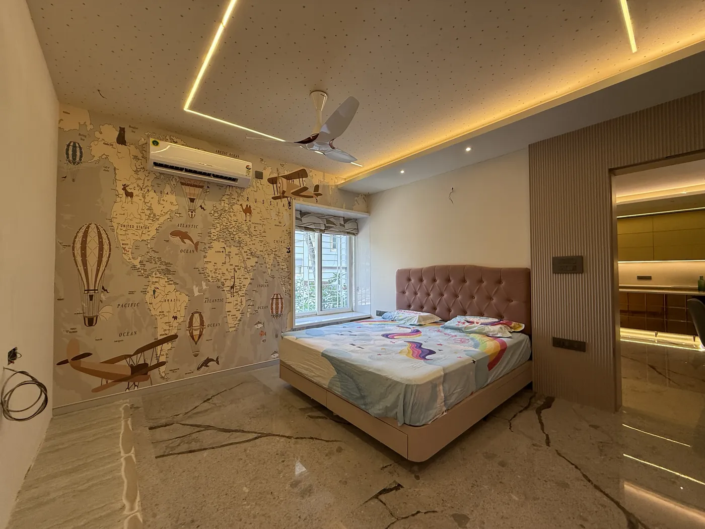 Children's bedroom with a hot air balloon wall mural and a tufted headboard