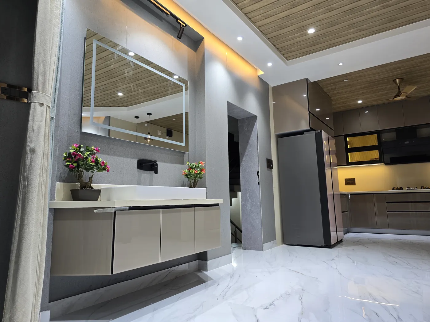 Kitchen and dining area with a backlit mirror panel and tall storage