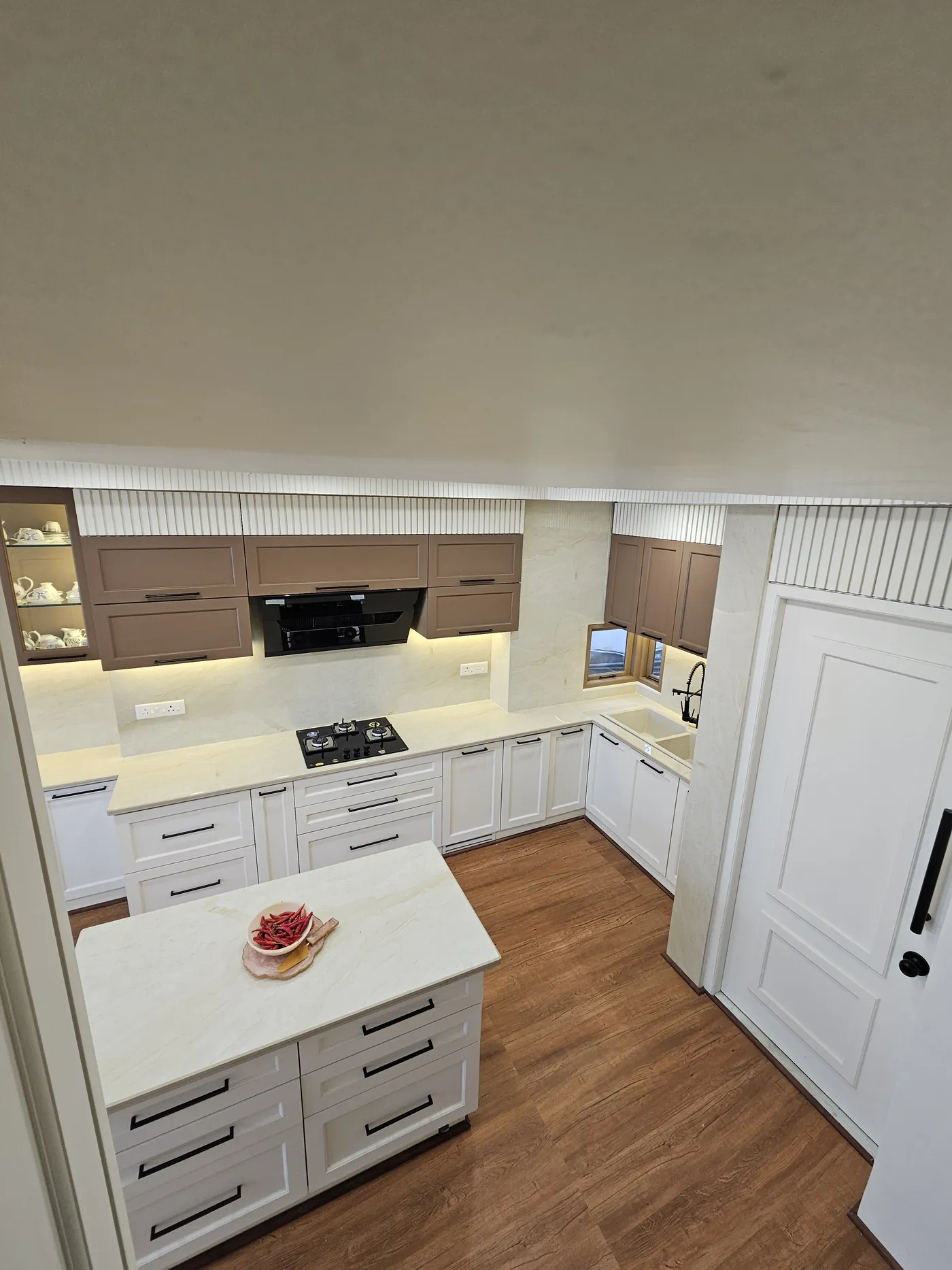 White shaker kitchen with a timber floor and an island worktop