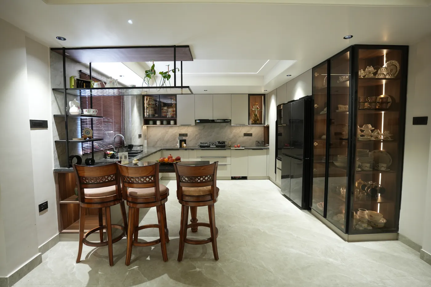 Kitchen breakfast bar with timber stools and a glazed display cabinet beyond