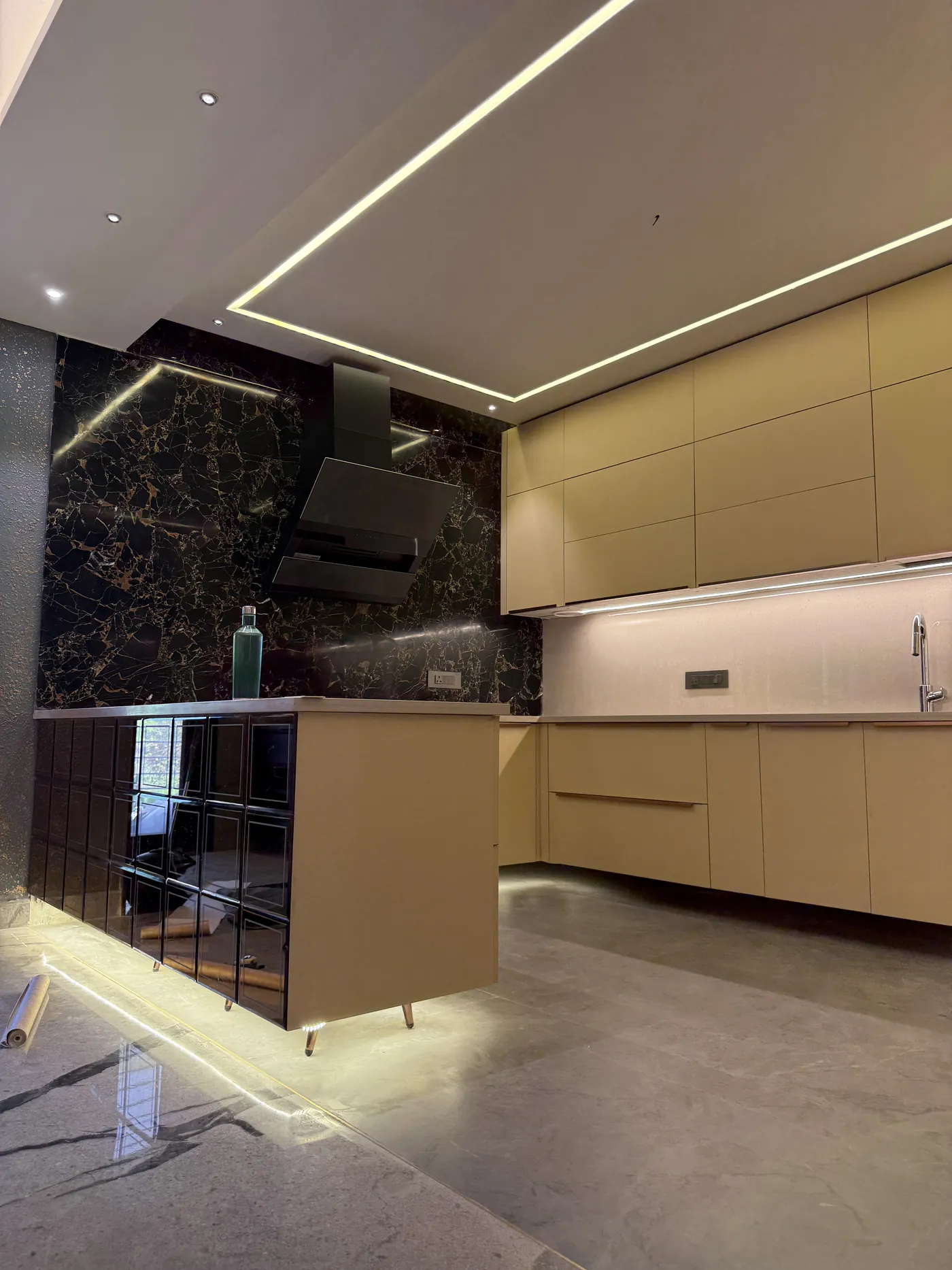 Modular kitchen in cream with a black marble splashback and chimney