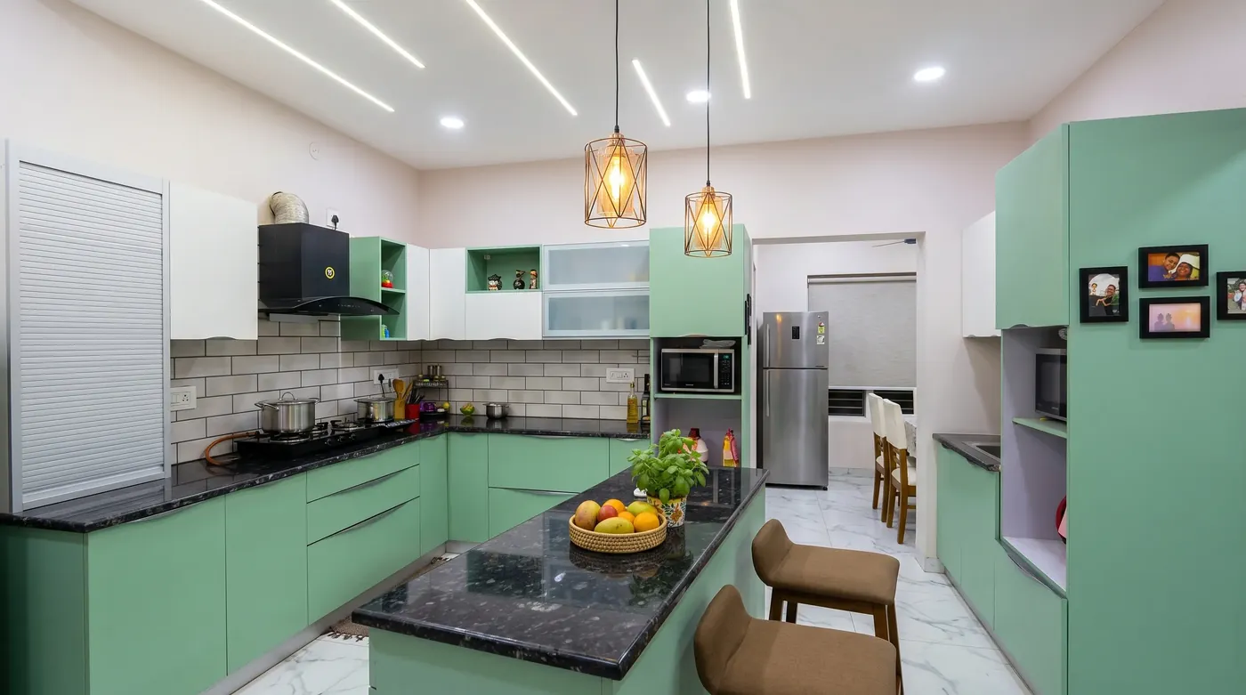 Sage green modular kitchen with a granite worktop and breakfast seating