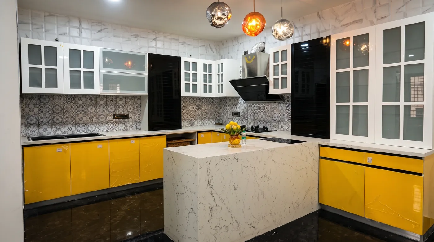 Yellow modular kitchen with a marble island and glazed wall units