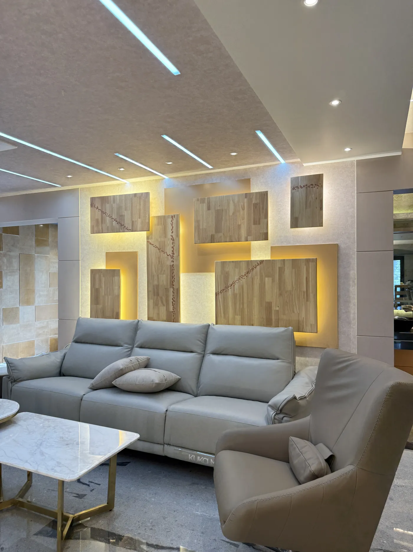 Living room with an L-shaped sofa and backlit timber wall panels