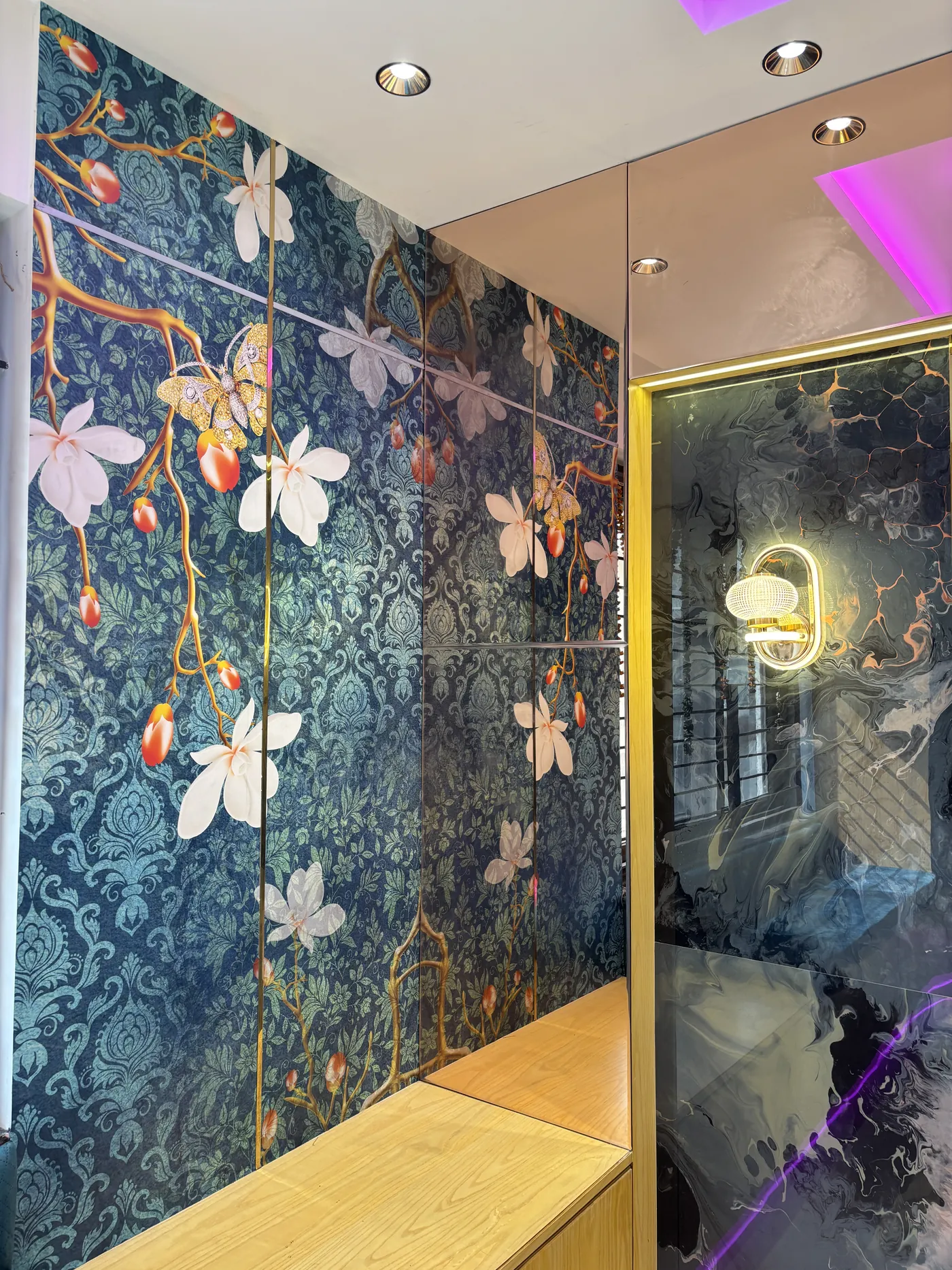 Patterned feature wall panel with a gold-framed mirror alongside