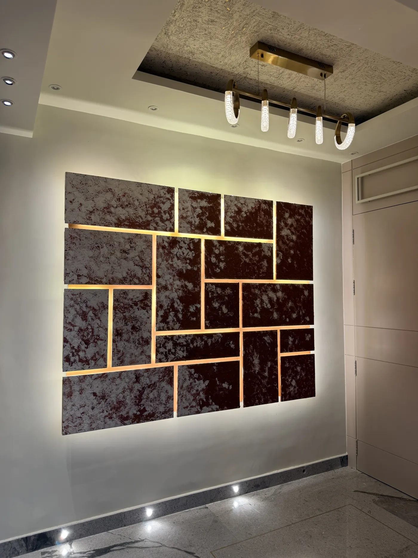 Feature wall of marble insets divided by brass trims